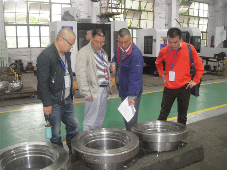 飞球公司营销中心副总监国姜伟(右2)在向客人介绍精加工的零件